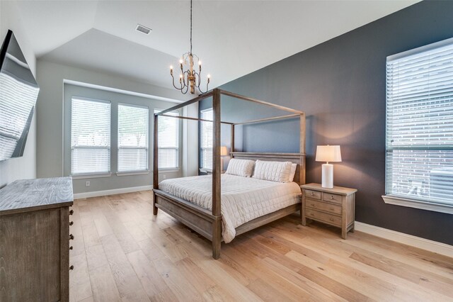 bedroom featuring baseboards, a notable chandelier, light wood-style floors, and visible vents