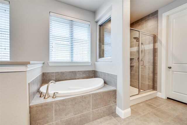 bathroom featuring a bath, tile patterned flooring, and a stall shower