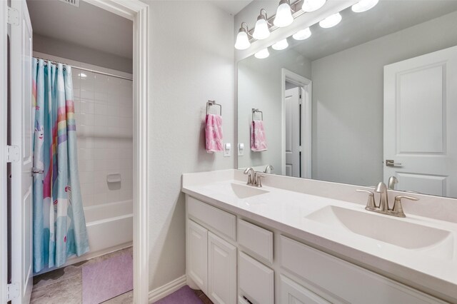 full bathroom with double vanity, shower / bathtub combination with curtain, baseboards, and a sink