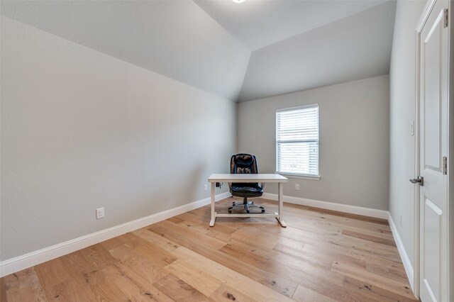 office space with light wood-style floors, lofted ceiling, and baseboards