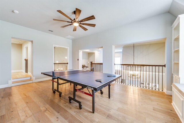 playroom with light wood-style floors, visible vents, baseboards, and ceiling fan with notable chandelier