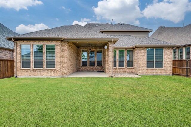 rear view of house with brick siding, fence, a ceiling fan, and a shingled roof
