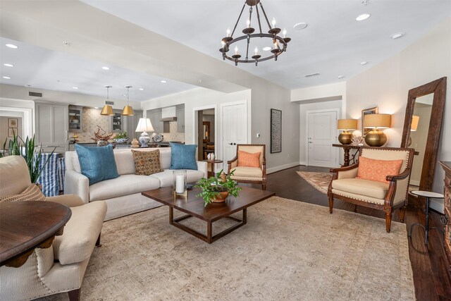 living room with an inviting chandelier, light wood finished floors, and recessed lighting