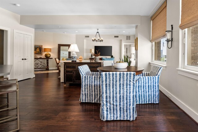 dining area with a chandelier, dark wood finished floors, visible vents, and baseboards