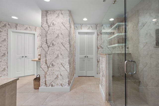 full bath with recessed lighting, a closet, tile patterned flooring, and a stall shower