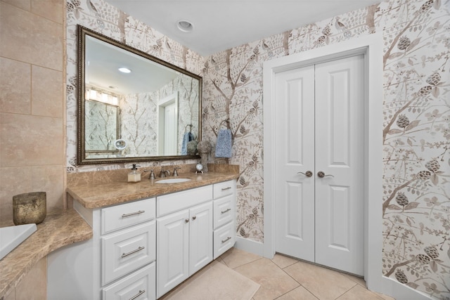 bathroom with wallpapered walls, vanity, and tile patterned flooring