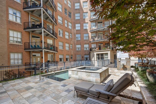 view of swimming pool with a community hot tub