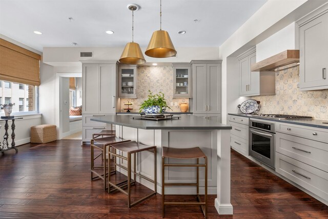 kitchen featuring stainless steel appliances, dark countertops, and tasteful backsplash