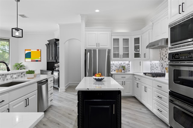 kitchen featuring tasteful backsplash, a sink, stainless steel appliances, wall chimney exhaust hood, and recessed lighting