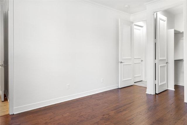 422 Mustang Dr, Sunnyvale, TX 75182 - unfurnished bedroom with dark wood-type flooring, baseboards, ornamental molding, and a walk in closet