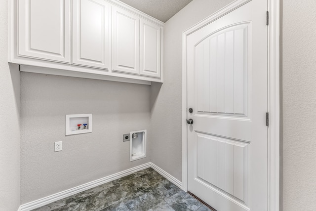 washroom with electric dryer hookup, a textured ceiling, cabinet space, baseboards, and hookup for a washing machine
