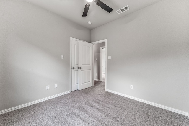spare room with visible vents, carpet flooring, baseboards, and a ceiling fan