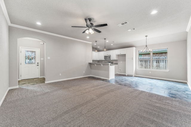 unfurnished living room with carpet floors, ceiling fan, and plenty of natural light