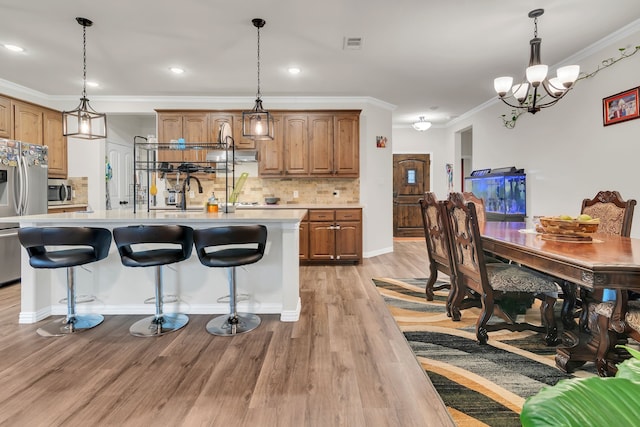 1728 Rio Secco Dr, Fort Worth, TX 76131 - kitchen with stainless steel appliances, backsplash, a chandelier, light wood-style floors, and light countertops
