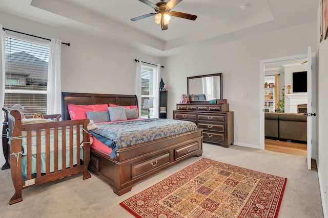 1728 Rio Secco Dr, Fort Worth, TX 76131 - bedroom with light colored carpet, a fireplace, a ceiling fan, and a raised ceiling