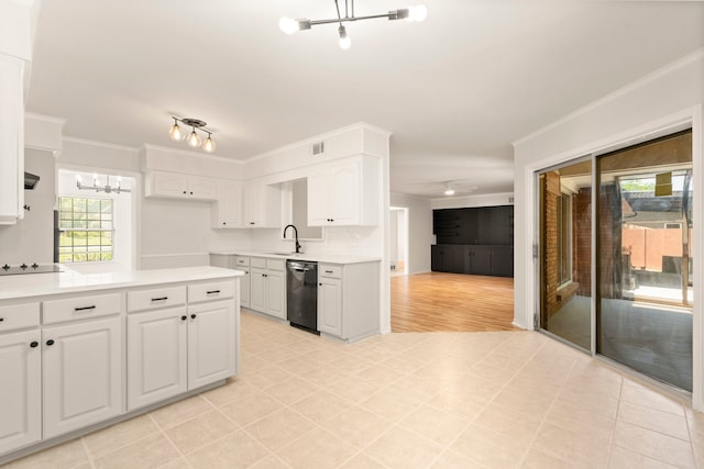 kitchen featuring a sink, black appliances, an inviting chandelier, light countertops, and white cabinets