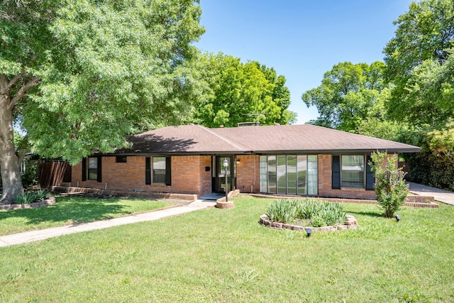 ranch-style house with a front lawn and brick siding
