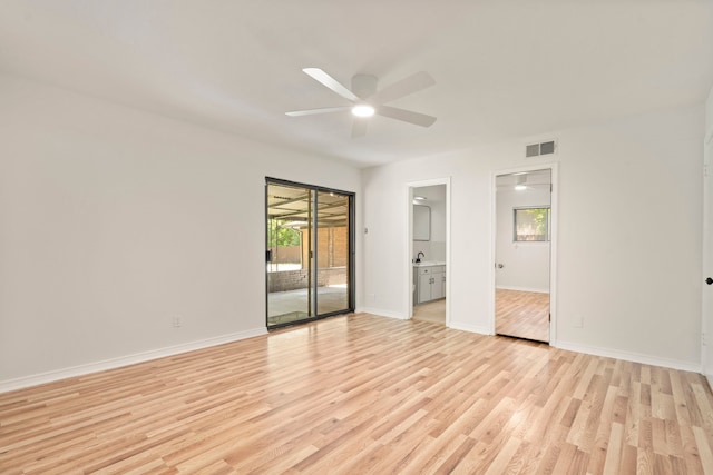 spare room featuring ceiling fan, a healthy amount of sunlight, light wood-style flooring, and visible vents