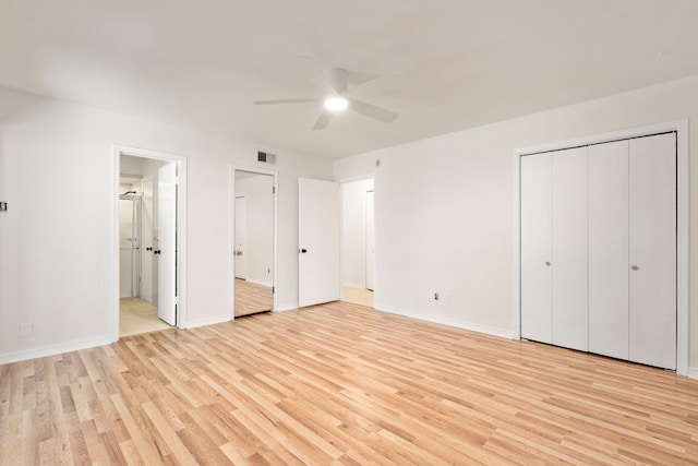 unfurnished bedroom featuring ensuite bathroom, visible vents, a ceiling fan, baseboards, and light wood-style floors