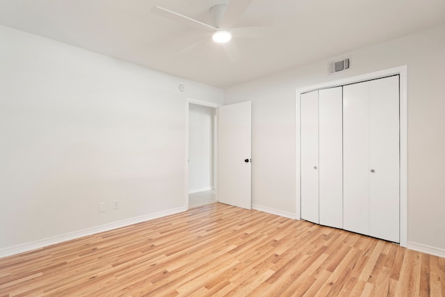 unfurnished bedroom with light wood finished floors, a closet, visible vents, baseboards, and ceiling fan
