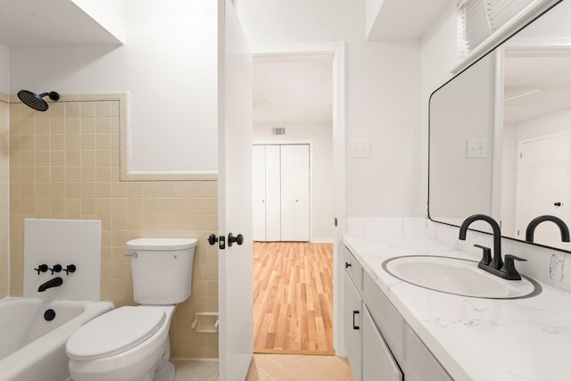 full bathroom featuring tile walls, toilet, a wainscoted wall, vanity, and tile patterned floors