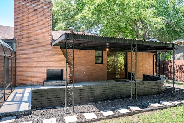 back of house featuring a chimney, brick siding, and fence