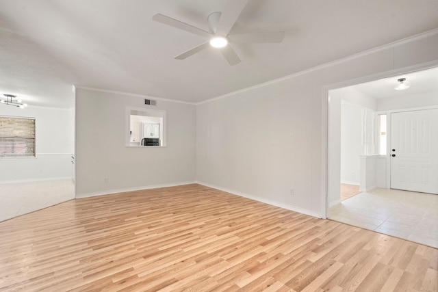 interior space with ornamental molding, visible vents, light wood finished floors, a ceiling fan, and baseboards