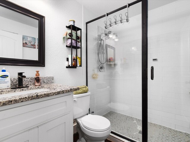 full bathroom featuring a shower stall, toilet, vanity, and baseboard heating