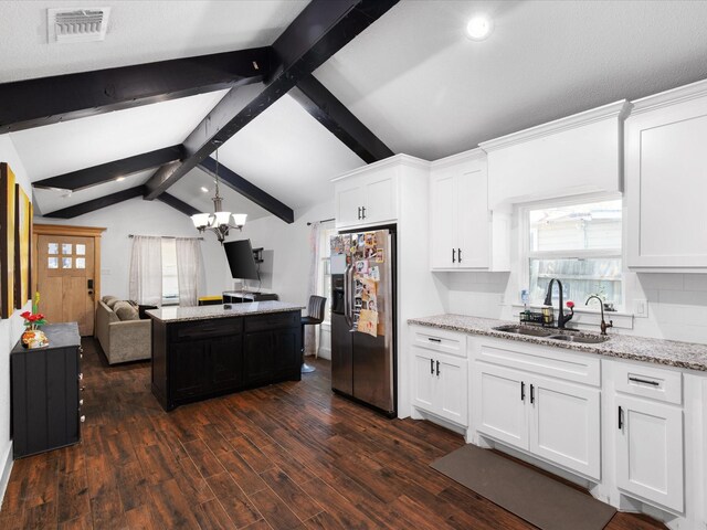kitchen with a sink, lofted ceiling with beams, open floor plan, stainless steel fridge with ice dispenser, and dark wood-style flooring