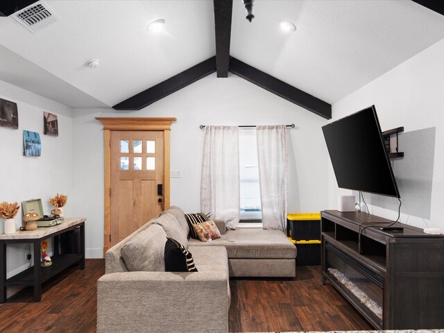 living area featuring lofted ceiling with beams, wood finished floors, and visible vents
