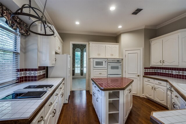 1405 Chesapeake Dr, Plano, TX 75093 - kitchen with white appliances, tile countertops, dark wood-style floors, open shelves, and crown molding