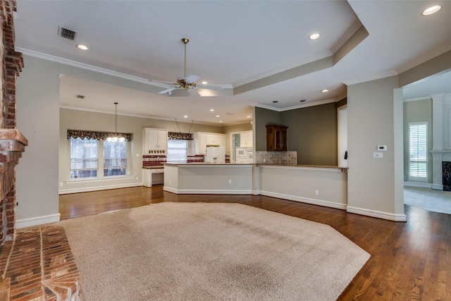 1405 Chesapeake Dr, Plano, TX 75093 - living room featuring a brick fireplace, ceiling fan, dark wood finished floors, a raised ceiling, and ornamental molding