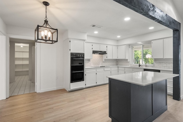 3319 Sheffield Dr, Arlington, TX 76013 - kitchen with a sink, under cabinet range hood, black appliances, white cabinetry, and light countertops