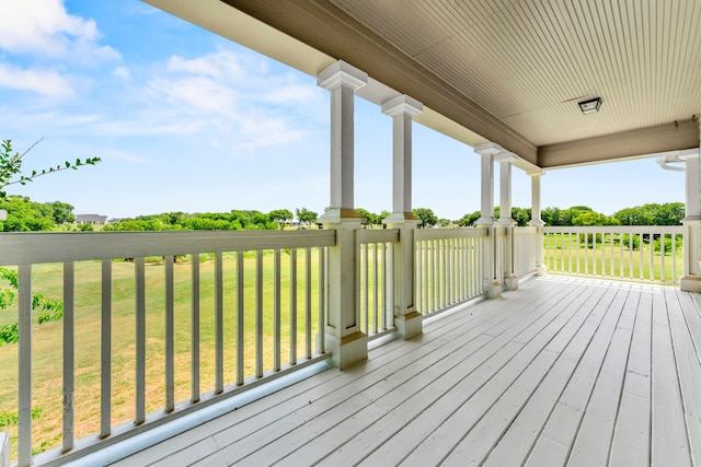 wooden deck featuring a porch and a lawn