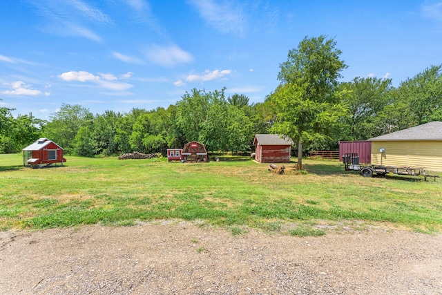 view of yard featuring an outdoor structure, a storage unit, and fence