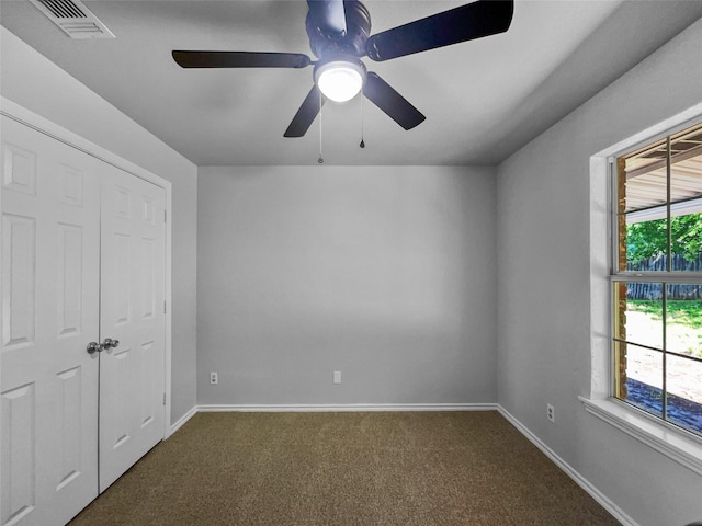 316 W 3rd Ter, Springtown, TX 76082 - unfurnished bedroom with dark carpet, baseboards, a ceiling fan, and visible vents