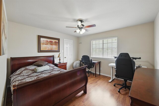 bedroom with baseboards, wood finished floors, and ceiling fan