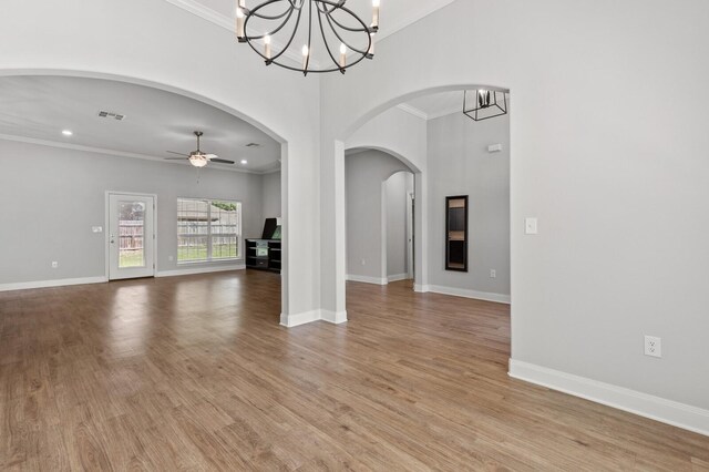 interior space with ornamental molding, light wood-style floors, and ceiling fan with notable chandelier