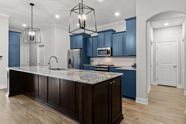 kitchen featuring a chandelier, appliances with stainless steel finishes, blue cabinetry, and a sink