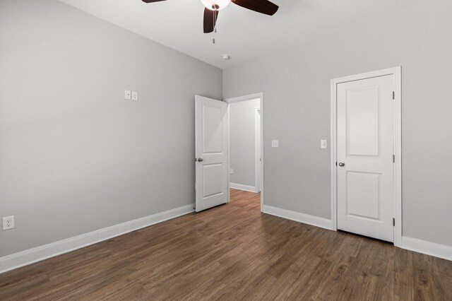 unfurnished bedroom with wood finished floors, baseboards, and ceiling fan