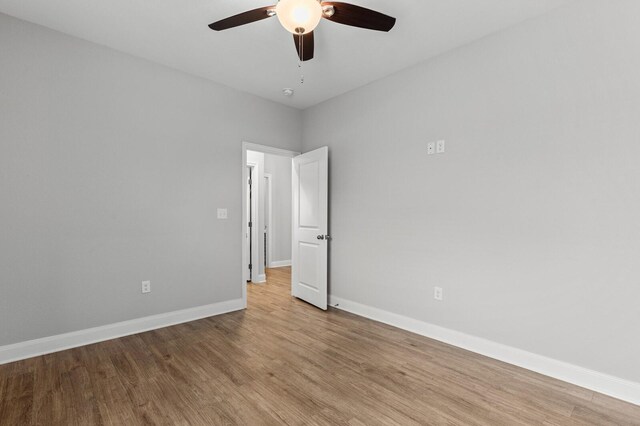 unfurnished room featuring baseboards, a ceiling fan, and light wood finished floors