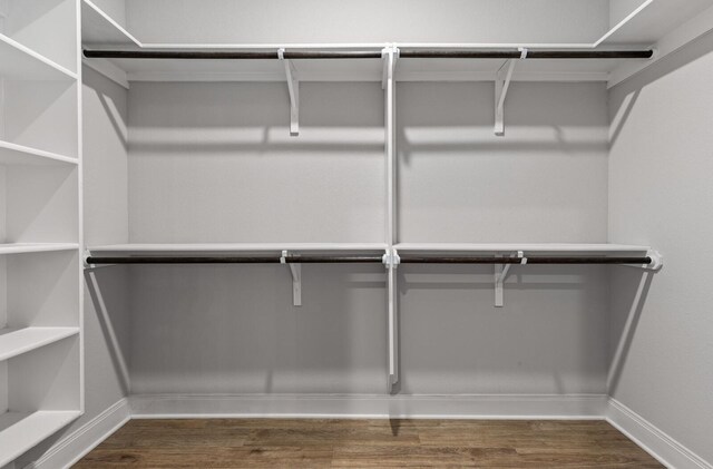 walk in closet with wood finished floors