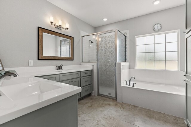 bathroom featuring double vanity, a garden tub, a stall shower, and a sink