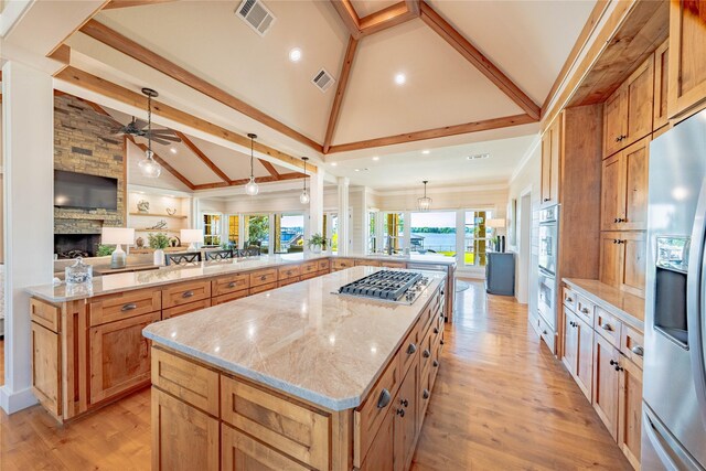 kitchen featuring a spacious island, open floor plan, stainless steel appliances, and visible vents
