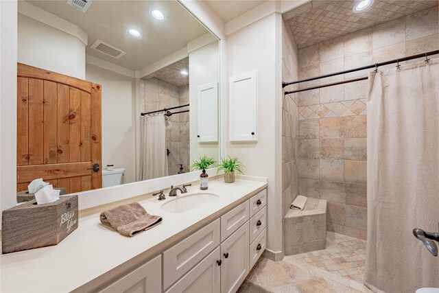 bathroom with visible vents, recessed lighting, vanity, and tiled shower