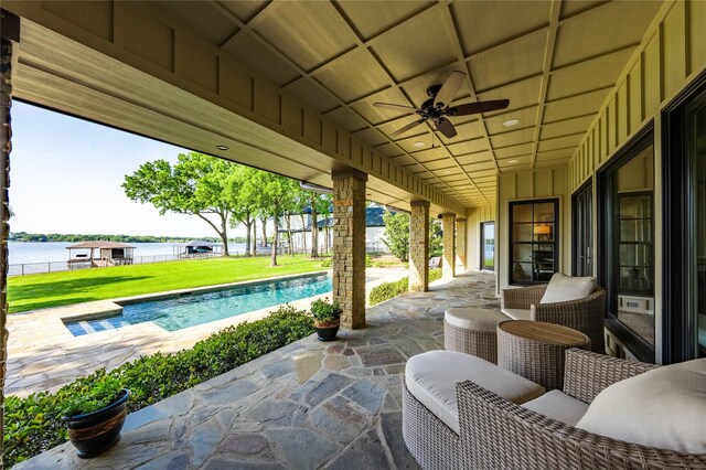 view of patio featuring ceiling fan, an outdoor pool, and a water view