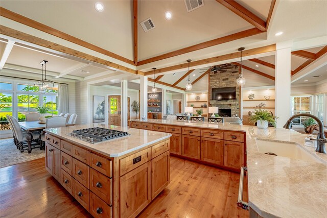 kitchen with visible vents, open floor plan, stainless steel gas cooktop, and a sink