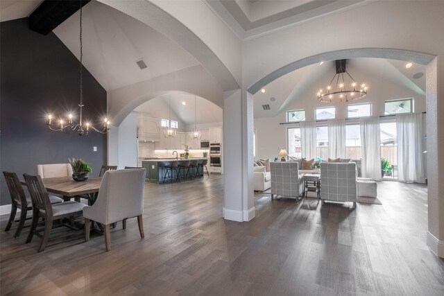 dining space featuring high vaulted ceiling, a chandelier, and dark wood-style floors