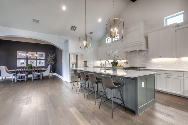kitchen featuring high end fridge, a notable chandelier, visible vents, and high vaulted ceiling