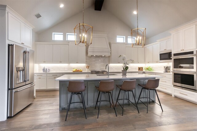kitchen featuring an inviting chandelier, high vaulted ceiling, and stainless steel appliances